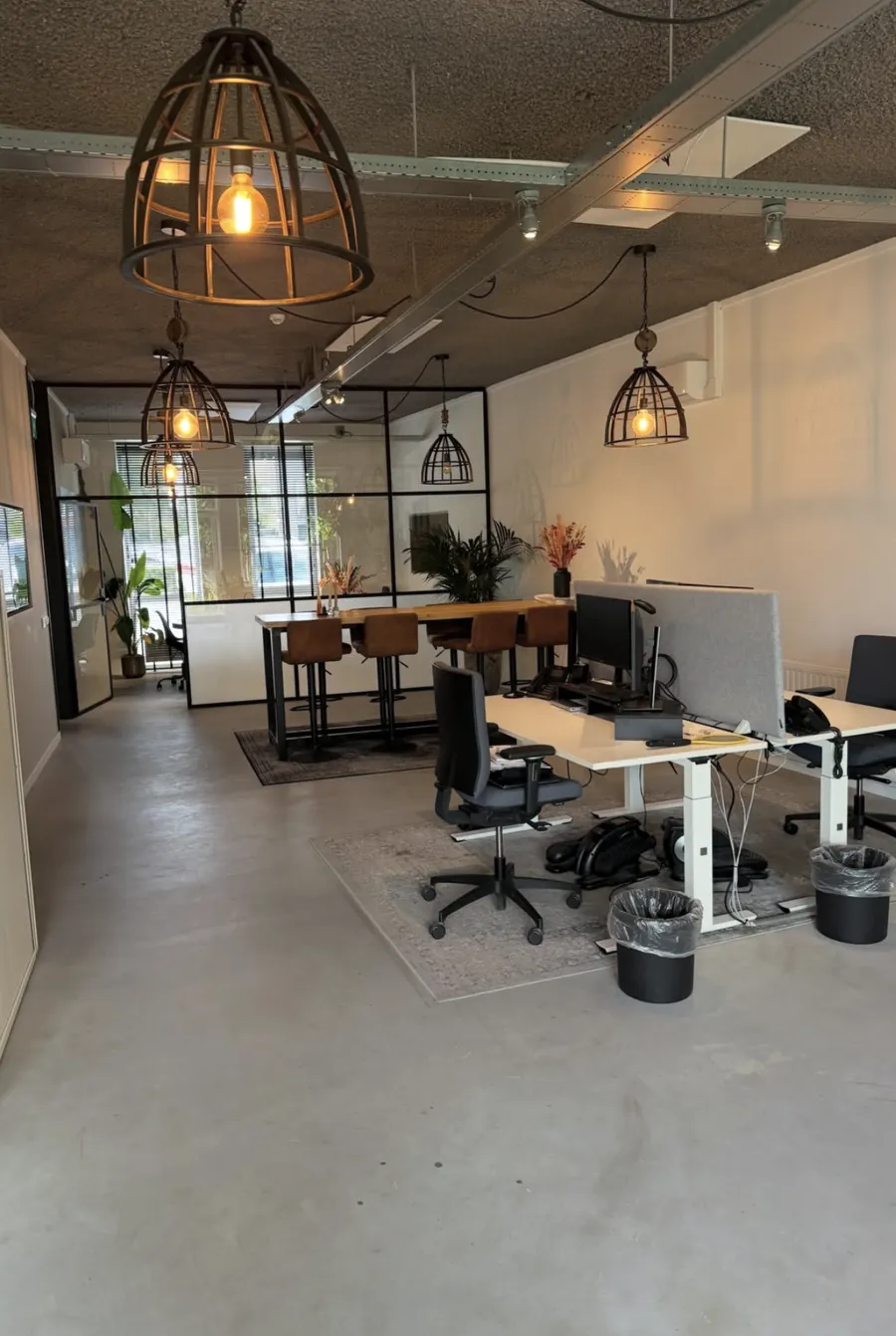 Schone kantoortuin met bureaus en een glazen wand